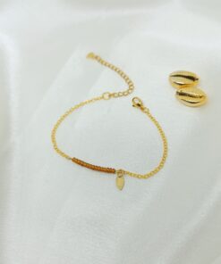 Photo d'un bracelet or et perles marron avec cauri en or