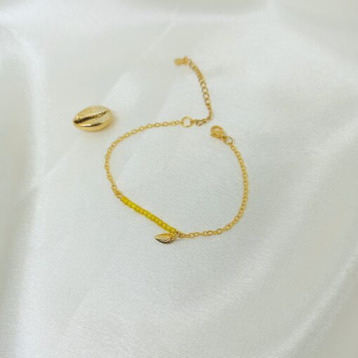 Photo d'un bracelet or et perles jaune avec cauri en or